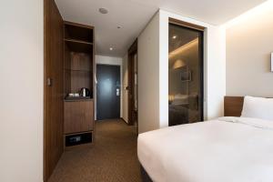 Postel nebo postele na pokoji v ubytování Ramada Encore by Wyndham Busan Haeundae