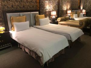 ein Hotelzimmer mit 2 Betten und einem Sofa in der Unterkunft Crystal Business Motel in Hsinchu
