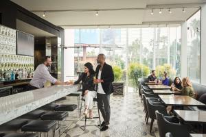 un homme et une femme debout dans un bar dans l'établissement Andaz West Hollywood-a concept by Hyatt, à Los Angeles