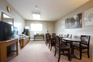 a dining room with a table and chairs and a television at Knights Inn Lindsay in Lindsay
