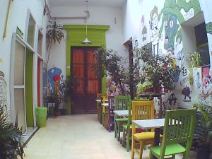 a restaurant with tables and chairs and a red door at 06 Central Hostel Buenos Aires in Buenos Aires