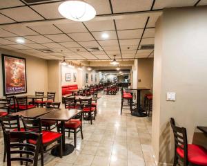 a dining room with tables and red chairs at Clarion Inn & Suites Miami International Airport in Miami