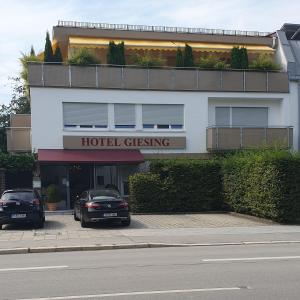 a hotel with two cars parked in front of a building at Hotel Giesing in Munich