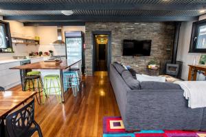 un soggiorno con divano grigio e una cucina di Amber Lodge Mt Buller a Mount Buller