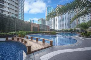 a swimming pool in a city with tall buildings at The Alpha Suites in Manila