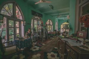 una mujer en una habitación con paredes y ventanas verdes en Ranjit's Svaasa Amritsar, en Amritsar 77 fotos más