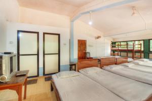 a room with four beds and a table and a tv at Hotel Kismat Mahal in Calangute