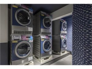 a row of washing machines in a laundry room at The Millennials Fukuoka in Fukuoka