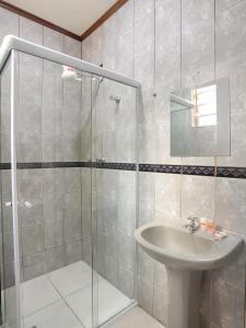 y baño con lavabo y ducha acristalada. en Belém Hotel, en São Paulo