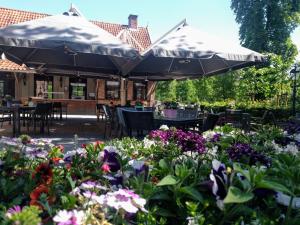 an outdoor patio with umbrellas and flowers at Fletcher Hotel-Restaurant De Broeierd-Enschede in Enschede