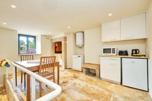 a kitchen with white cabinets and a table with a tableablish at Sintra Bliss A Part in Sintra