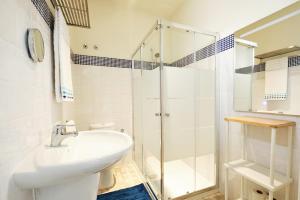 a white bathroom with a sink and a shower at Sintra Bliss A Part in Sintra