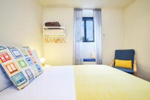a bedroom with a large bed and a blue chair at Sintra Bliss A Part in Sintra