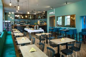 a restaurant with wooden tables and blue chairs at Happy Tower in Krakow