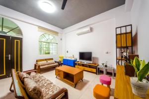a living room with a couch and a tv at Chi's House B&B in Taitung City