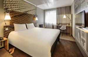 una camera d'albergo con un letto grande e una scrivania di ibis Aachen Marschiertor - Aix-la-Chapelle ad Aquisgrana