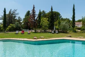 einen Pool im Garten mit Stühlen und Bäumen in der Unterkunft Quinta da Arrábida in Sesimbra