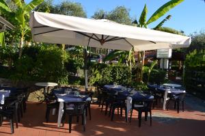 a group of tables and chairs under a white umbrella at Campeggio Gianna Golfo dei Poeti in Lerici