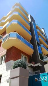 um edifício amarelo com uma plantadora à frente em Hotel Bolivar em San Benedetto del Tronto