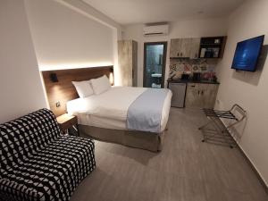 a hotel room with a bed and a couch at Shalos Studios - Cozy Central in Ayia Napa +10 photos