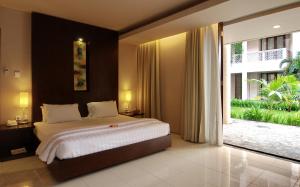 a bedroom with a large bed and a large window at The Pade Hotel in Banda Aceh