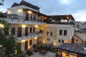 a large white building with balconies on top of it at Cappadocia Ozbek Stone House in Göreme