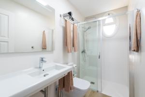 un bagno bianco con lavandino e doccia di Apartamentos Cordial Judoca Beach a Playa del Ingles