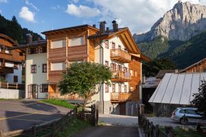 a house in a village with a mountain in the background at Casa Chris by AMA Val di Fassa in Pozza di Fassa +8 photos