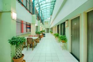 an empty hallway with tables and chairs in a building at Hotel Grand Ashwin in Nashik