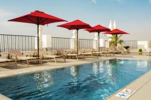 a swimming pool with umbrellas and chairs and a swimming pool at Riu Plaza España in Madrid