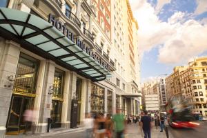 a group of people walking down a street in front of a store at Riu Plaza España in Madrid