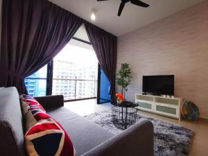 a living room with a couch and a flat screen tv at Atlantis Residence Melaka in Malacca