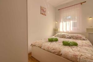 una camera da letto con un letto con due cuscini verdi di Charming villa Petroro with pool, 900m from the beach a Peroj Altre 57 foto