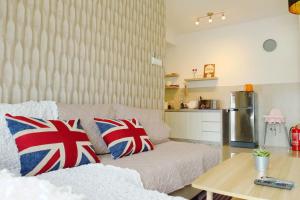 a living room with a couch with british pillows on it at Atlantis Residence by Harmoni Harbour in Melaka