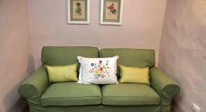 a green couch with three pillows on it at Residenza Antico Chianti in Panzano