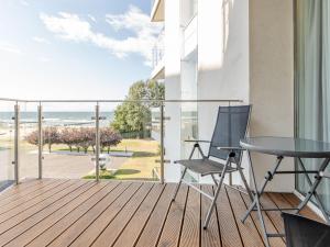 balcón con mesa, sillas y vistas al océano en Apartament z widokiem na morze i aneksem kuchennym Ultra MARINE en Kołobrzeg