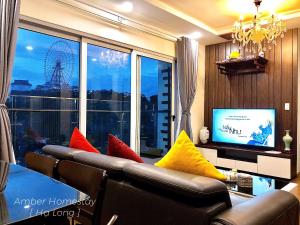 a living room with a couch with colorful pillows at Amber Homestay Hạ Long in Ha Long