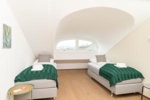 two beds in a room with an arched window at Rooftop Stephansdom in Vienna