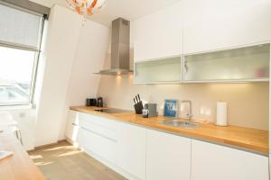a kitchen with white cabinets and a sink at Rooftop Stephansdom in Vienna