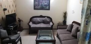 a living room with a couch and a chair and a tv at Hotel Home Stay Dwarka in New Delhi +20 photos