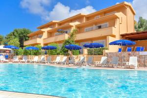 a hotel with a swimming pool with chairs and umbrellas at Residence Le Onde in Badesi