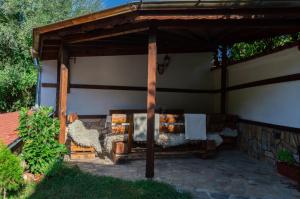 a wooden pavilion with two chairs and a table at Гюмюрджински Снежник in Kirkovo +6 photos