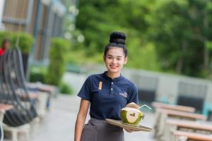 Eine Frau mit einem Teller mit einer Avocado drauf. in der Unterkunft My Beach Resort Phuket in Panwa Beach