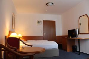 a hotel room with a bed and a table and a mirror at Hotel Alpina in Kranjska Gora
