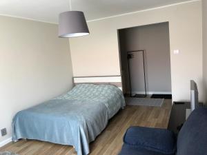 um quarto com uma cama, uma cadeira e uma porta em 1-Bedroom apartment in city centre em Paide