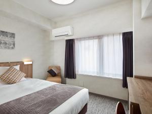 a bedroom with a bed and a window at HOTEL MYSTAYS Kiyosumi shirakawa in Tokyo