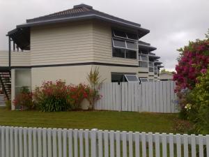 a house with a white fence in front of it at Motel Six in Hamilton