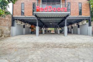 un edificio in mattoni con un cartello rosso a forma di libro sopra di RedDoorz Syariah @ Babadan Baru Jakal a Yogyakarta