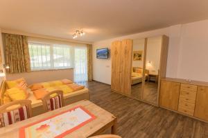 Schlafzimmer mit einem Bett, einem Tisch und einem Spiegel in der Unterkunft Appartment Hotel Mitterer in Saalbach-Hinterglemm