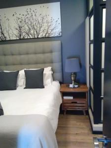 a bedroom with a bed and a table with a lamp at The Rosebank in Johannesburg